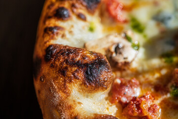Macro shot of golden pizza crust with melted cheese mushrooms and sausage.