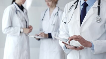 Healthcare professional using a digital tablet for patient data management, doctors collaborating on medical records, modern clinic team focusing on health technology - Powered by Adobe