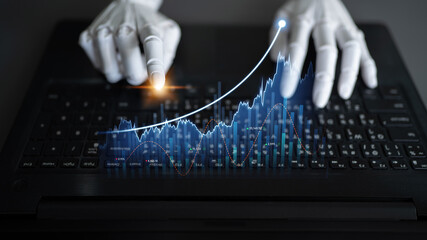 A close-up view of robotic hands operating a laptop keyboard while displaying animated digital financial data, symbolizing innovation in financial technology and AI. Scalp
