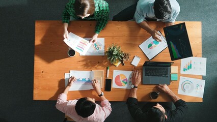 Top down view of smart business people hand working together to analyze chart. Skilled marketing team discussing about financial plan at table with stock market exchange report placed. Convocation.