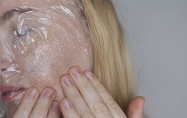Microplastics in cosmetics. A woman applied a care cream to her skin, now it is covered with...
