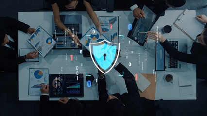 A group of professionals collaborates in a modern office, reviewing cybersecurity strategies with...