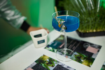 Vibrant lime cocktail presentation, Bartender displays colorful drink elegantly, Focus on bartender presenting vibrant green drink in stylish setting with soft lighting