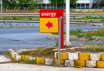 Sign with red arrow showing direction to petrol station outside on public road