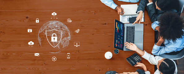 A diverse team engages in a collaborative session focused on data security strategies, surrounded by modern technology and digital resources, enhancing their cybersecurity efforts. Trope