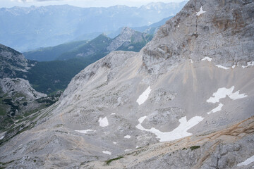 Tiny hikers walking through vast alpine landscape with mountains, Triglav National Park, Slovenia
