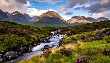 A serene landscape showcases a vibrant stream meandering through verdant fields, framed by majestic mountains beneath a cloudy sky