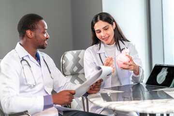 Two professional doctors discussing a heart model for medical education in a modern clinic office, analyzing patient information and healthcare concepts using professional communication and teamwork.