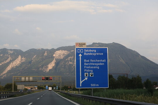 Autobahn Richtung Salzburg &ndash; Stra&szlig;enschild an der deutsch-&ouml;sterreichischen Grenze mit Alpenpanorama