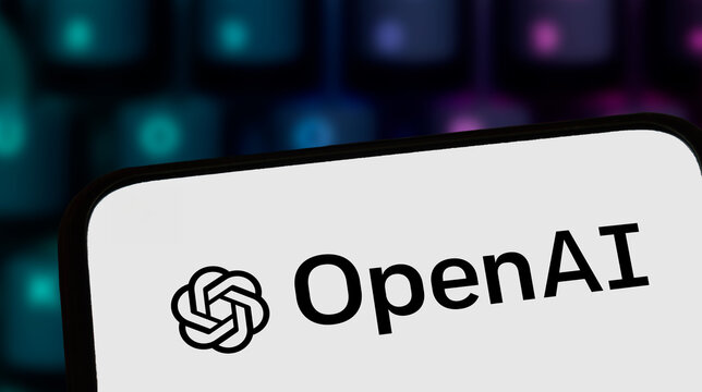 Warsaw, Poland - November 8, 2025: Close-up of a smartphone screen displaying the OpenAI logo. The background features a blurred colorful keyboard highlighting technology.