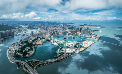 Obraz premium Panoramic aerial view of the entire city peninsula with a landmark tower and bridges on a sunny day in Macau.