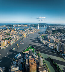 Panoramic cityscape of the inner harbor separating the two bustling cities on a clear sunny day in Macau.