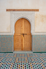 Highly decorated doorway framed by intricate zellige tiles and a patterned floor inside the...