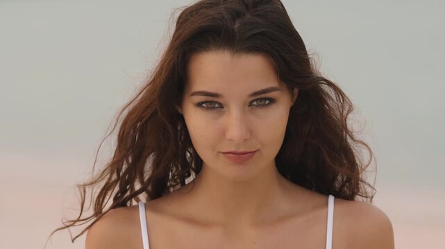 Shy Woman Smiling and Looking Down While Posing on the Beach