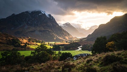 Stunning mountain vista with valley bathed in golden light under dramatic, cloud-streaked sky