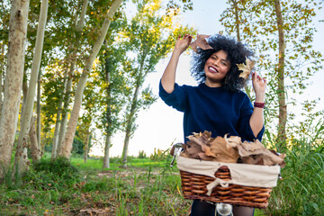Happy young woman enjoying autumn day with bicycle