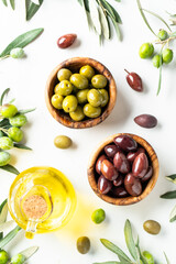 Olives and Olive oil in the bottle at white table.