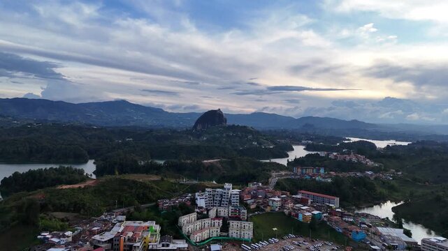 Aerial slowly flies forward, capturing a head-on view of the massive El Pe&ntilde;&oacute;n de Guatap&eacute; (La Piedra del Pe&ntilde;ol) rock formation and the surrounding lake and islands