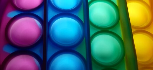 Vibrant rainbow pop it fidget toy close-up.
Close-up of a multicolored pop it fidget toy, featuring...