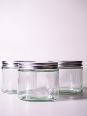 Clear glass jars with metallic lids ready for creative product packaging, storage solutions, or artisanal creations, offering a clean and modern aesthetic for branding.
