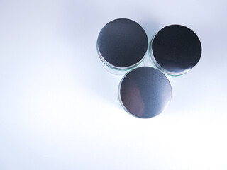Three sleek, modern metallic tins arranged on a clean white surface, ready for product packaging or branding.