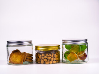 Three glass jars filled with delicious snacks and colorful treats create a visually appealing still life perfect for food blogs or advertising.