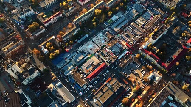 Backward drone shot pulling away from Central Market with panoramic view of downtown Chisinau at sunset