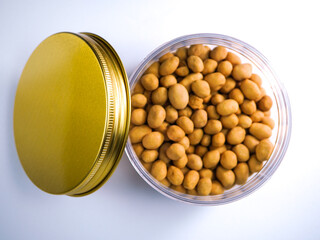 Crispy roasted peanuts in a clear container with a golden lid, perfect for snacks and culinary inspiration.