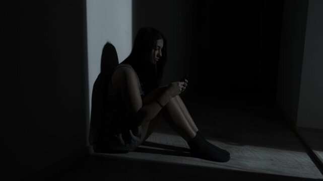 Woman texting during relationship conflict, intense digital argument in the dark room
