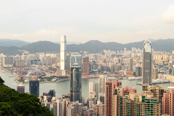 Naklejka premium Skyscraper scenery aerial view on top of buildings at evening in town Hong Kong. City with soft orange sunlight in evening beautiful with hotels and office tower large river flows through center.