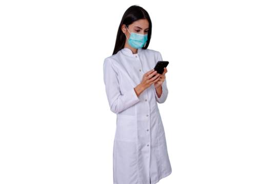 Female healthcare worker in lab coat and face mask using smartphone for medical communication and technology research