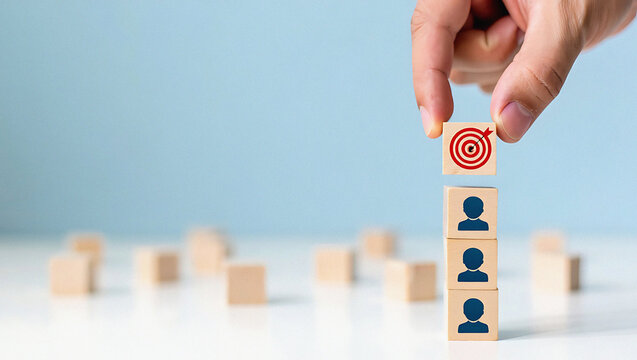 Strategic placement of target icon block atop human silhouette blocks signifies achieving goals and team success in business