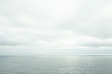 Calm blue sea meeting a tender sky with soft clouds — peaceful coastal scenery from the Faroe Islands, ideal for travel and nature lovers.