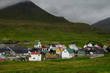 Picturesque view of Gjógv village in the Faroe Islands, surrounded by dramatic cliffs and lush green hills — a perfect stop for hiking and travel photography.