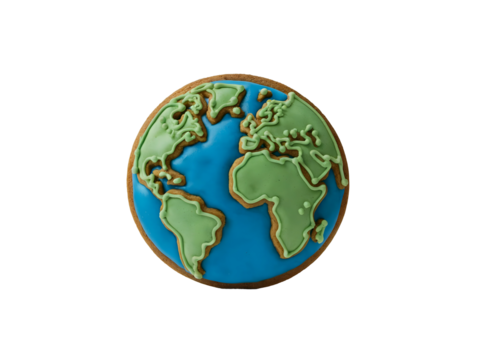 Gingerbread cookie shaped like planet Earth decorated with bright green and blue royal icing isolated on black background