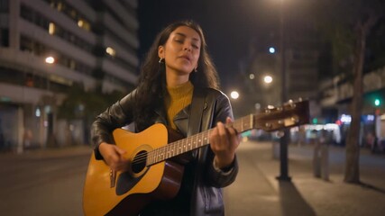 Ultra HD footage of street musician playing guitar under city lights with emotional atmosphere perfect for creative lifestyle and cultural storytelling visuals - Powered by Adobe