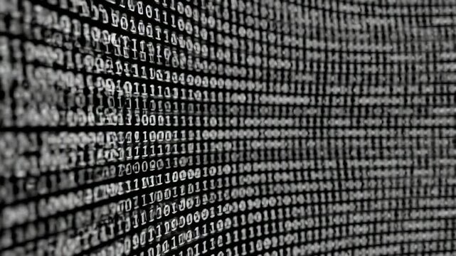 A close-up view presents a wall of binary code in shades of white against a black backdrop, creating a technological aesthetic