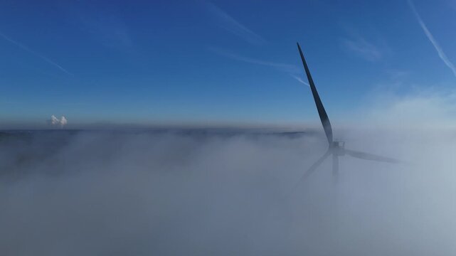 une &eacute;olienne tourne lentement dans le brouillard &agrave; Doncourt-les-Longuyon pendant qu'&agrave; 50 km de l&agrave; on aper&ccedil;oit la vapeur d'eau &eacute;mise par la centrale nucl&eacute;aire de Cattenom