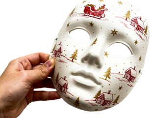 Hand holding a white ceramic mask decorated with a festive christmas village scene isolated on transparent background