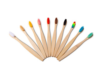 Nine natural bamboo toothbrushes with colorful bristles arranged in a fan shape, promoting sustainable dental hygiene, isolated on a white background