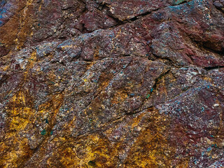 Aubergine red coloured rock patterns with orange colored iron deposits. Abstract texturized shapes.