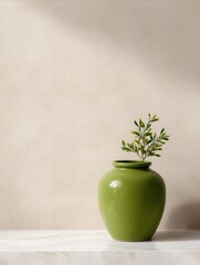 Green Vase With Small Leaves Sits on a White Surface in Soft Light