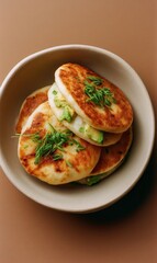 Delicious Arepas Stacked in a Bowl, Filled With Avocado and Topped With Green Dill Sprigs