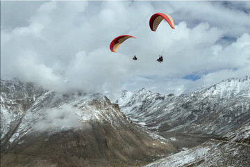 Tourists paragliding at Leh Ladakh with view of Himalayan mountain range.
