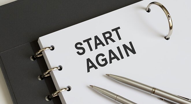 Start again message on open notebook with pens new beginnings