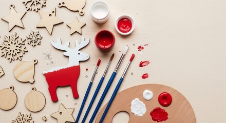 Christmas craft supplies with red reindeer and paints on wooden background
