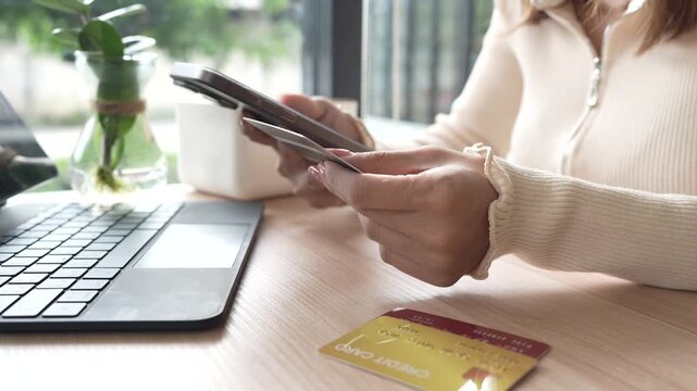 Close-up of a woman using a smartphone and holding a credit card for online shopping or payment, symbolizing digital finance and modern lifestyle.