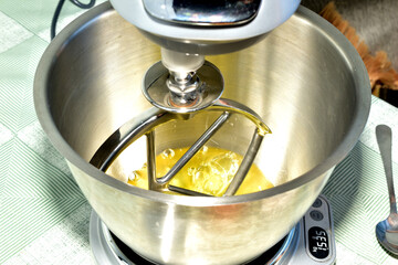 Top view of the metal bowl and whisk of a food processor.