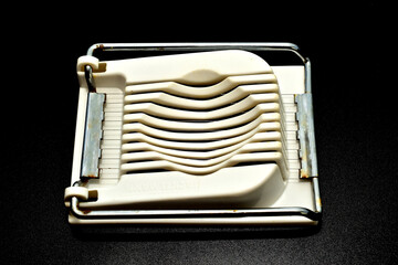 A plastic egg slicer kitchen tool. Designed for quickly and evenly slicing hard-boiled eggs.