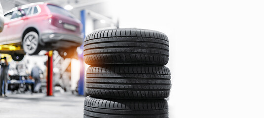 Concept car wheel service. Professional mechanic changing tires in garage, banner with copy space. © Parilov